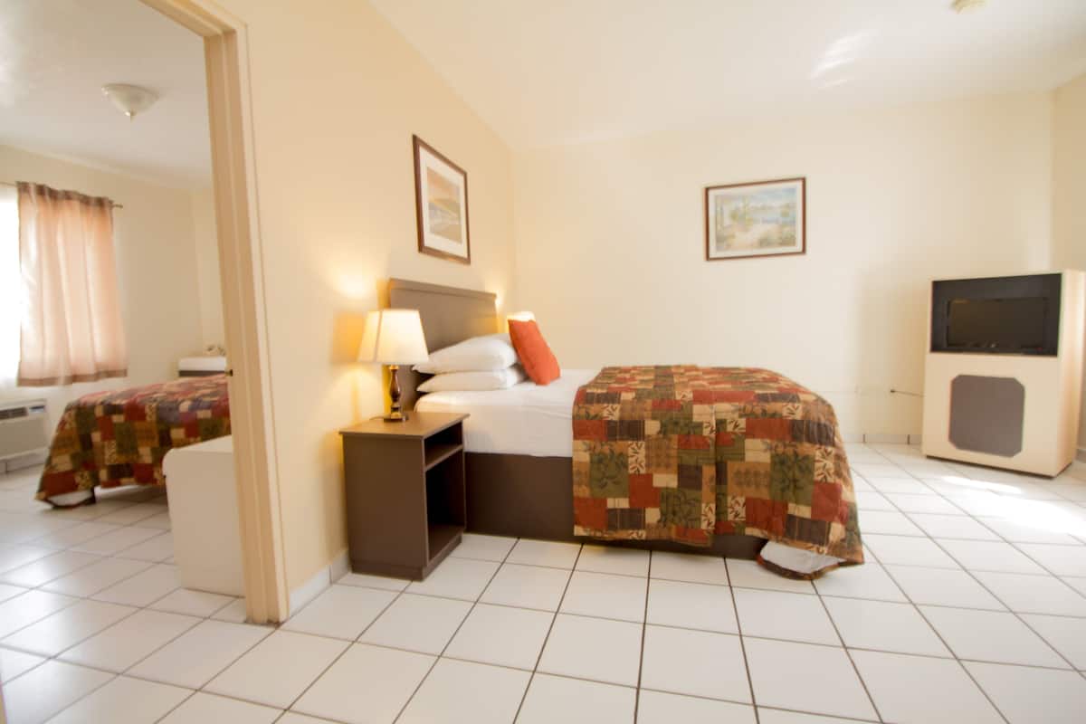 Une chambre d’hôtel équipée d’un lit, d’une table de chevet, d’une lampe et d’un téléviseur.
