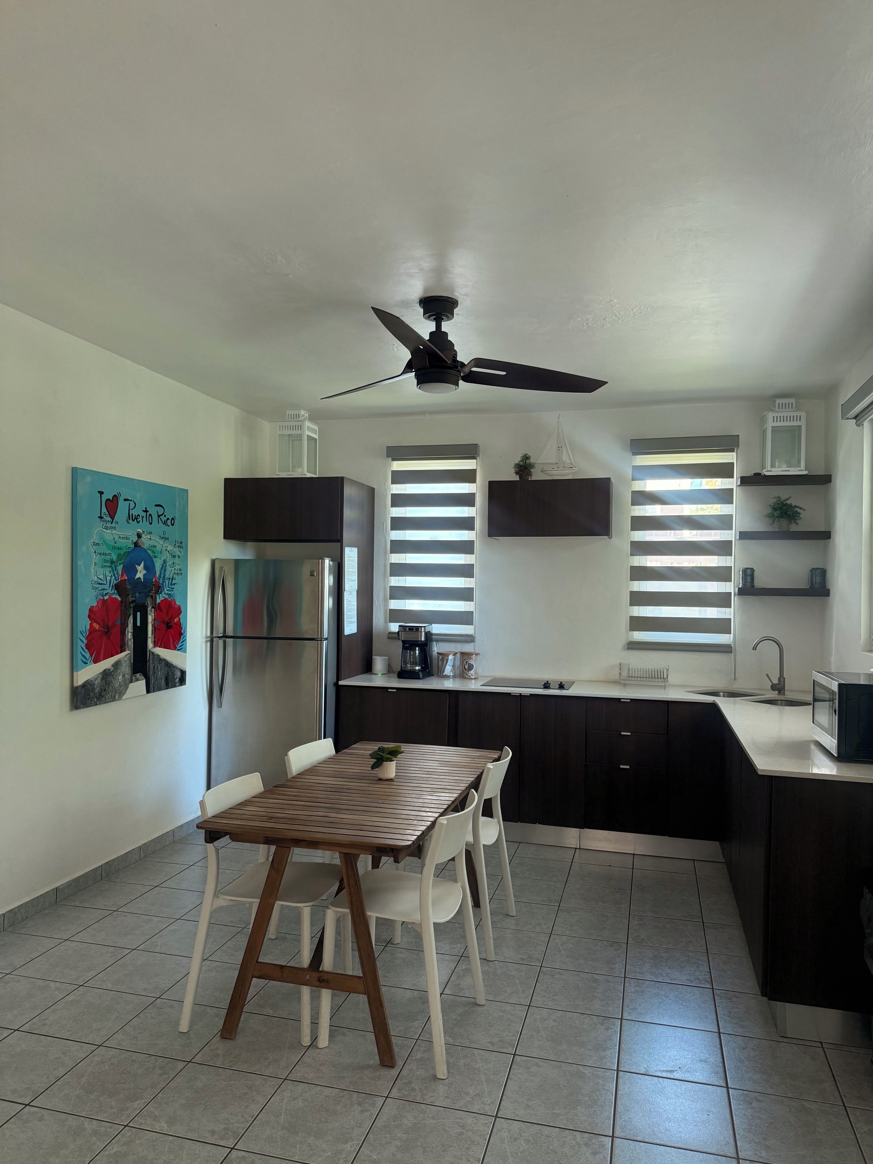 Uma cozinha com área de refeições, um ventilador de teto e um mapa fixado na parede.
