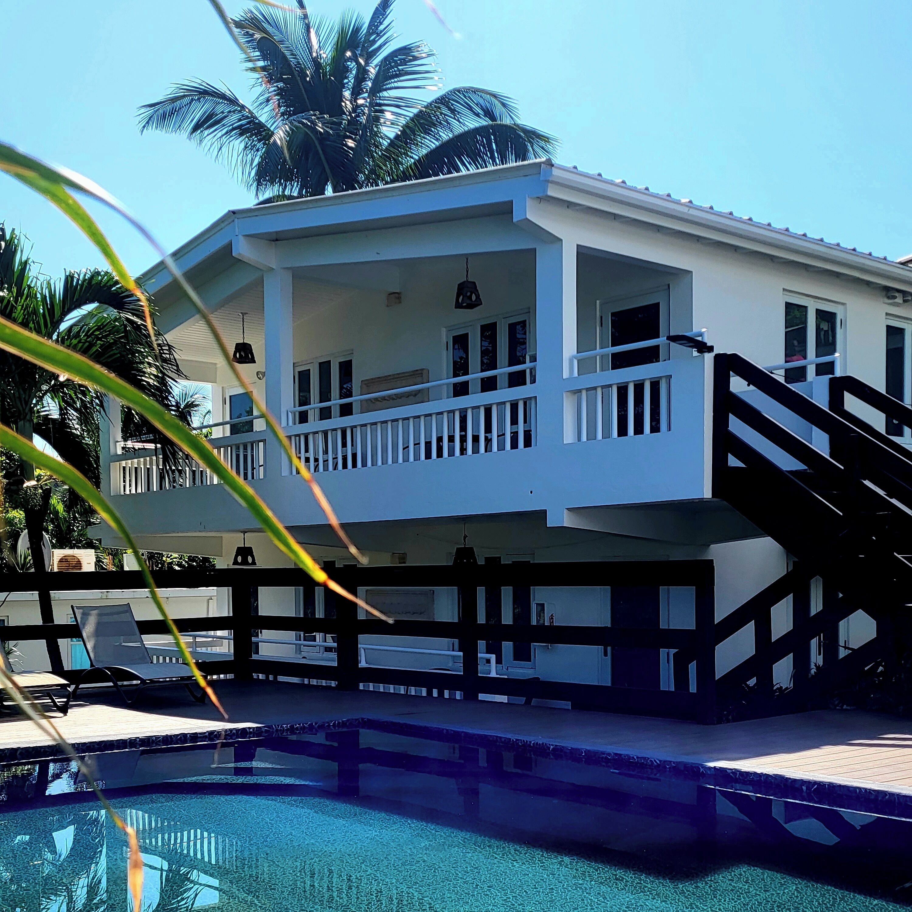 A two-story house with a balcony and a swimming pool.
