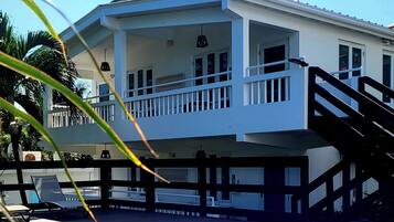 A two-story house with a balcony and a swimming pool.