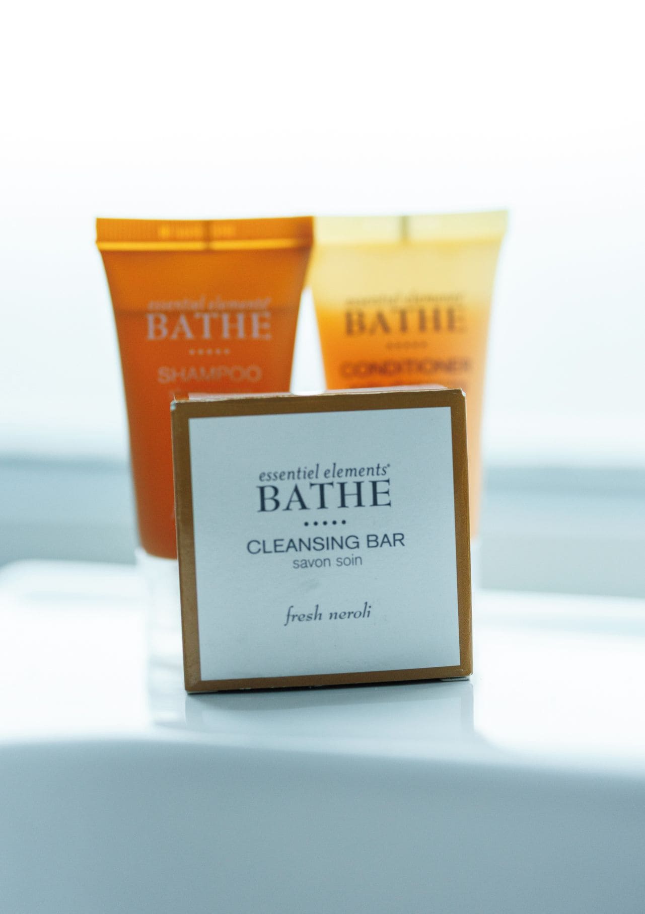 Un présentoir présentant un savon nettoyant et deux flacons de shampoing et d’après-shampoing.
