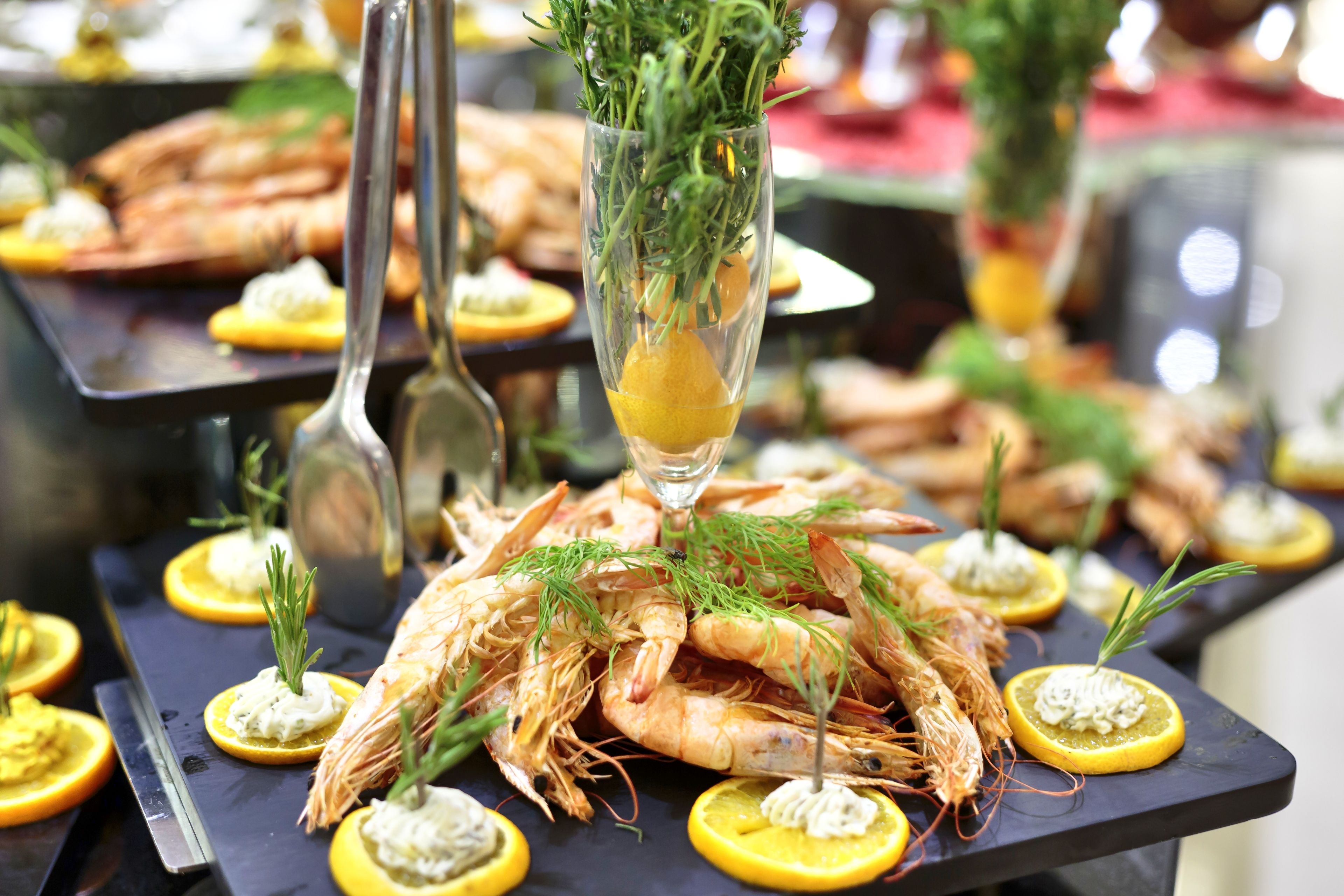 A buffet table with shrimp and lemon slices.