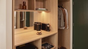 Una estantería de madera con una botella, libros y una cafetera.