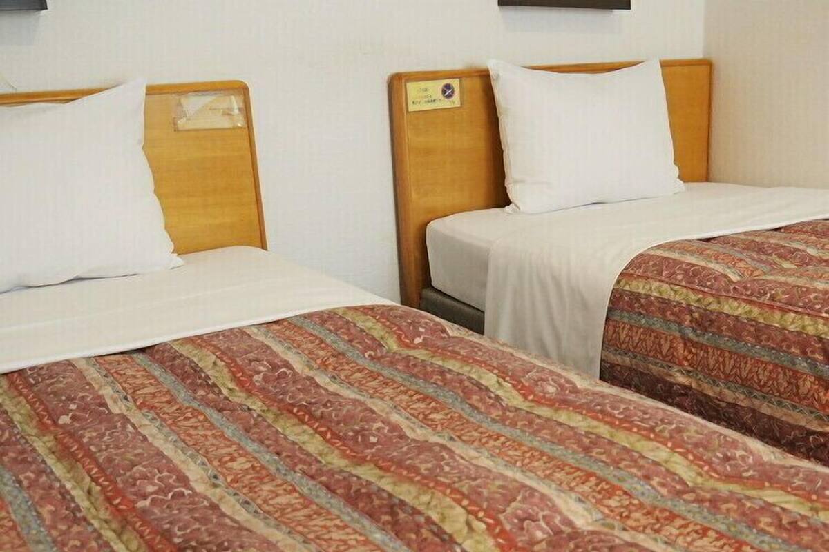 Two single beds with wooden headboards and white bedding.