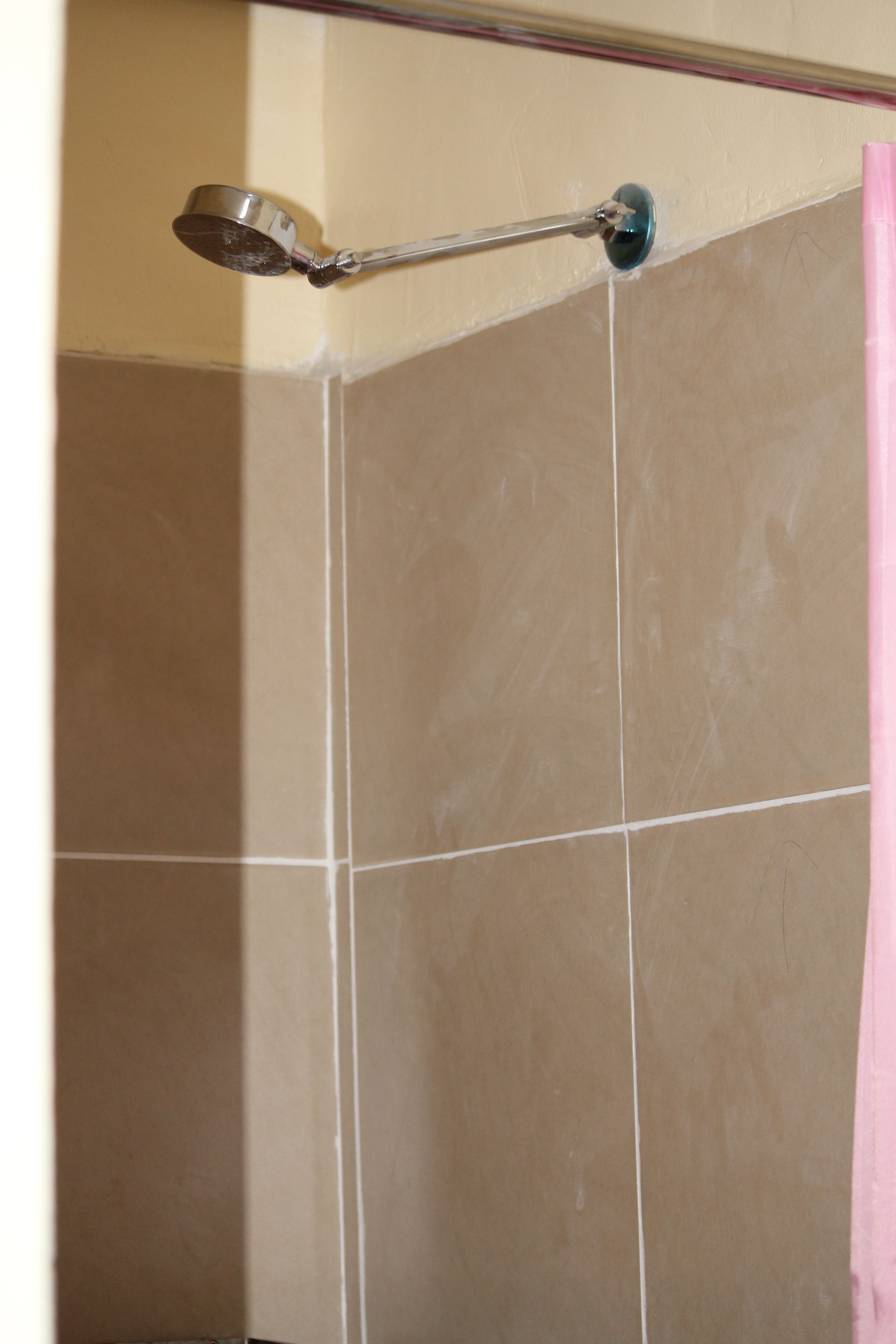 Una ducha con cabezal de ducha de mano fijado a la pared.