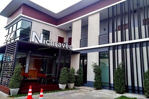 A modern building with a prominent sign reading "Nichravee". - Nichravee Resort Ubon Ratchathani (Ubon Ratchathani)
