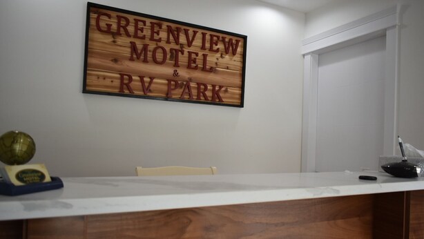 A reception desk with a sign reading "Greenview Motel & RV Park". - Greenview Motel and RV Park (Greenwood)
