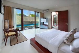 Habitación de hotel moderna con una cama grande, un escritorio con silla, televisión y vistas a una piscina.