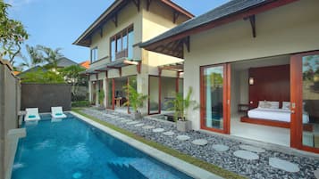 A modern house with a swimming pool, large windows, and a balcony.
