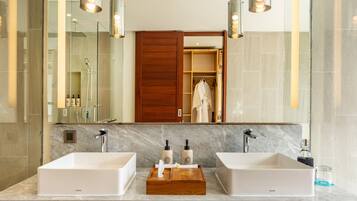 A modern bathroom with two sinks, a wooden vanity, and a large mirror.