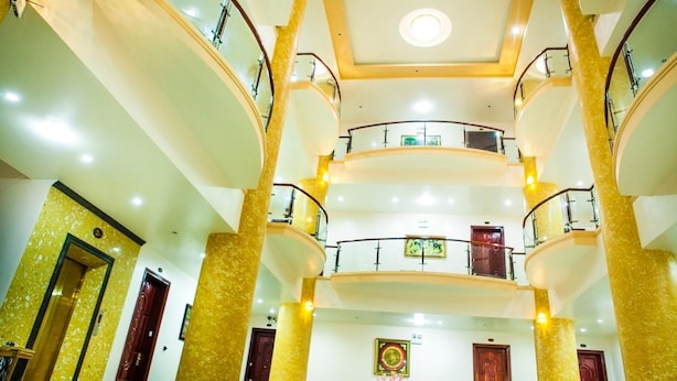 A multi-level atrium with a central staircase, glass railings, and a chandelier. - A1 Hotel Dien Bien (Dien Bien Phu)