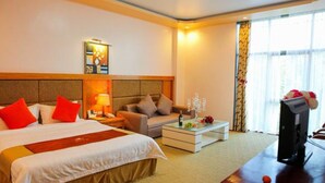 A hotel room with a large bed, a sofa, a coffee table, and a TV. - A1 Hotel Dien Bien (Dien Bien Phu)
