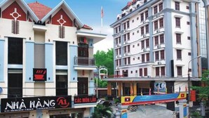 A hotel with multiple floors, balconies, and a prominent sign for 'NHA HANG'. - A1 Hotel Dien Bien (Dien Bien Phu)
