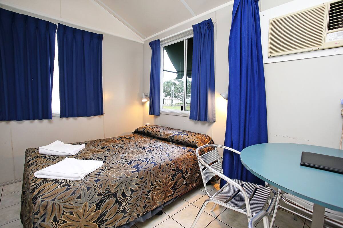Una habitación con una cama, una mesa y una silla.