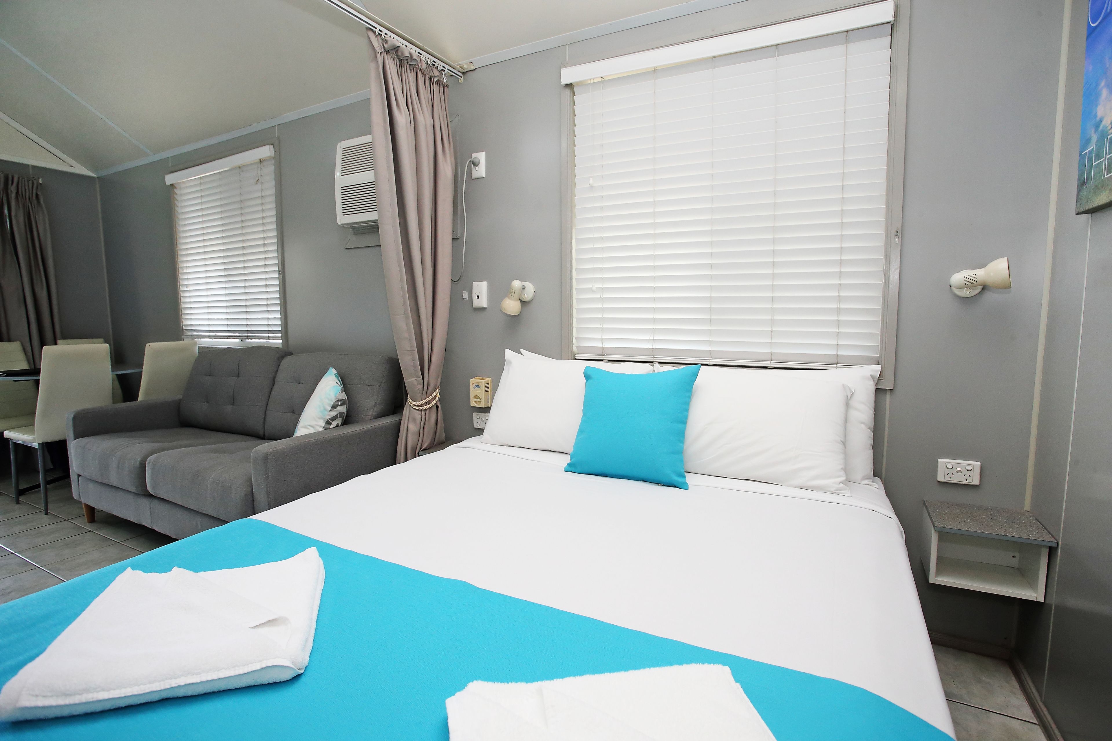 Una habitación de hotel con cama, sofá, escritorio y silla.