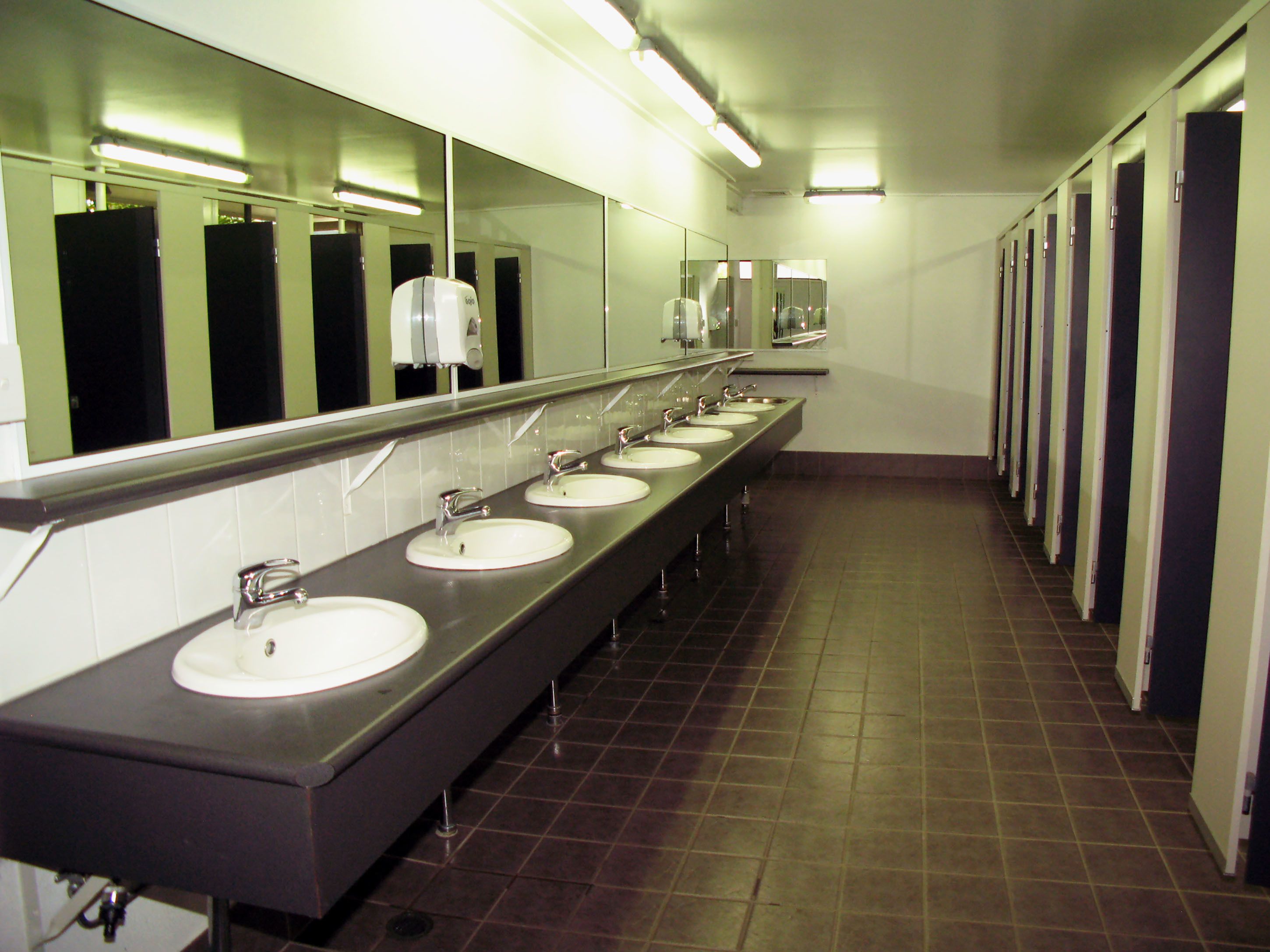 De vastes toilettes publiques dotées de nombreux lavabos et de plusieurs miroirs.