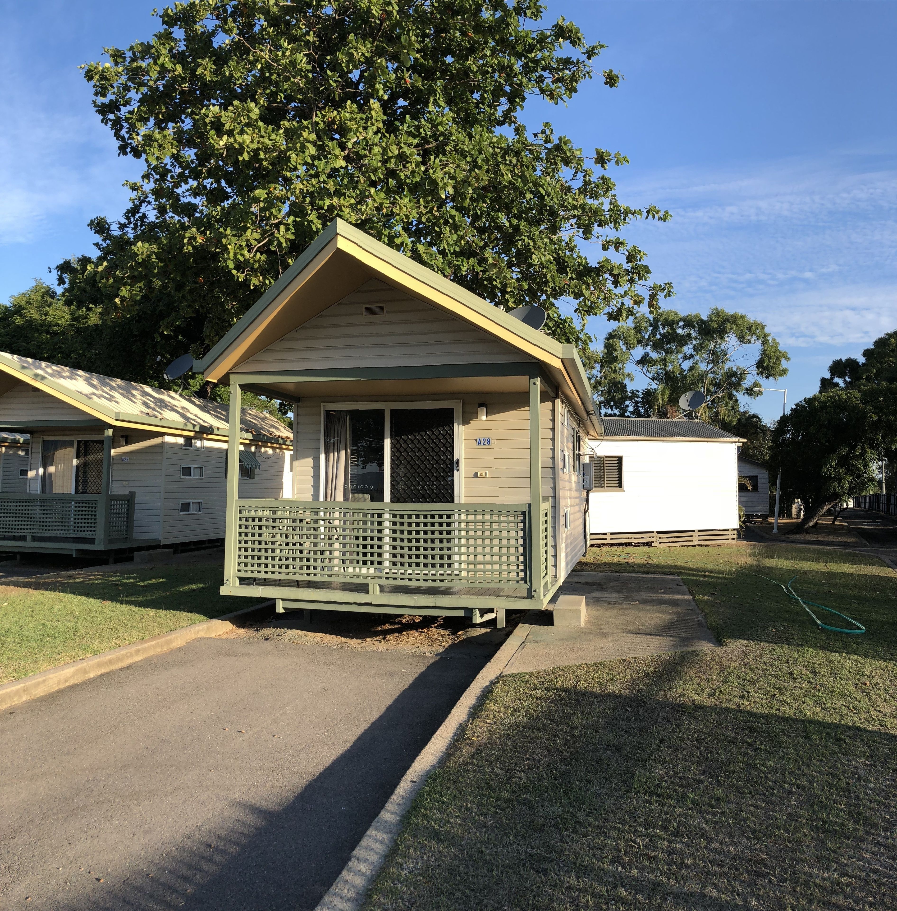 A small, single-story mobile home with a porch and a satellite dish.