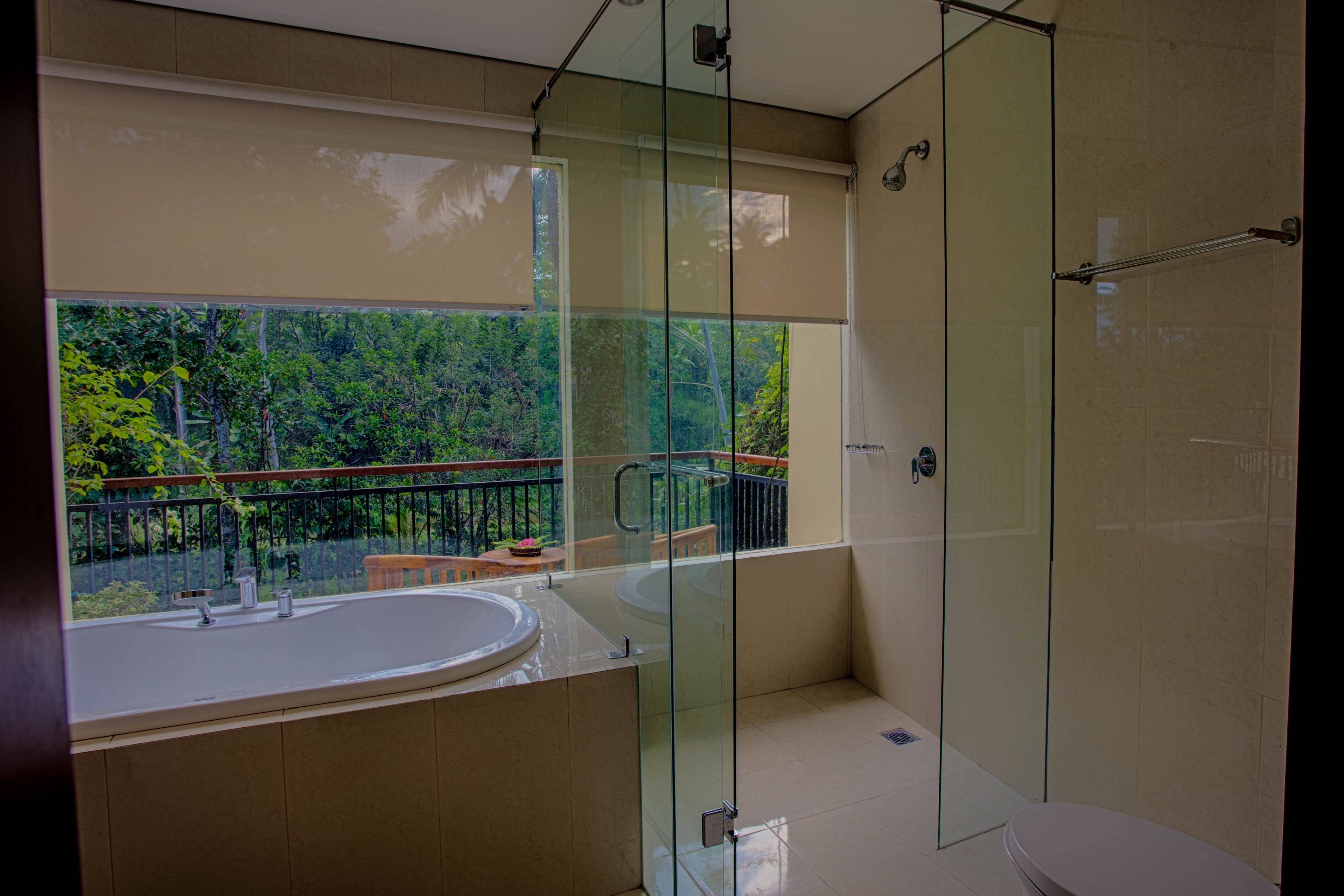 Ein modernes Badezimmer mit einer gläsernen Duschkabine, einem großen Waschbecken und Blick auf einen Balkon mit Geländer.