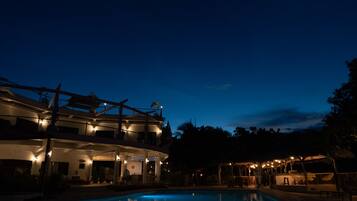 Vista frontal de la propiedad por la tarde o noche