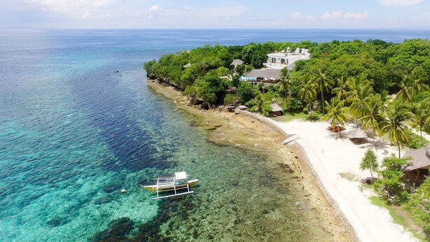 A coastal property with a beach, clear waters, and lush greenery. - Granada Beach Resort - Adults Only (Boljoon)