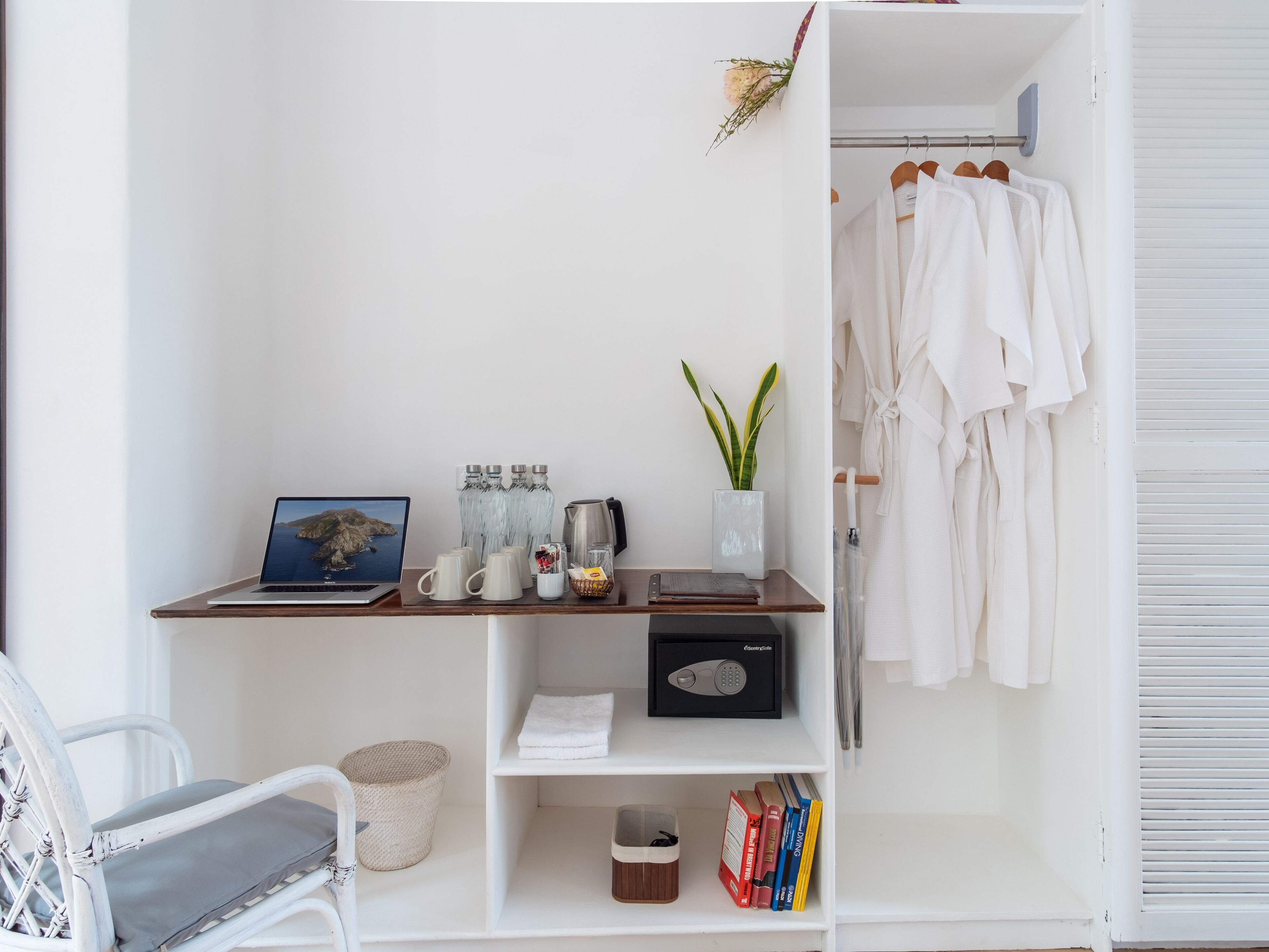 Una habitación ordenada con escritorio, ordenador portátil, estantería y armario.
