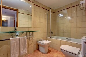 Ein modernes Badezimmer mit einem Glaskonstruktionswaschbecken, einer Toilette und einer Duschkabine aus Glas.