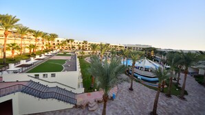 A resort with multiple-story buildings, palm trees, a pool area, and a well-maintained lawn. - Xperience Kiroseiz Premier (Sharm El Sheikh)