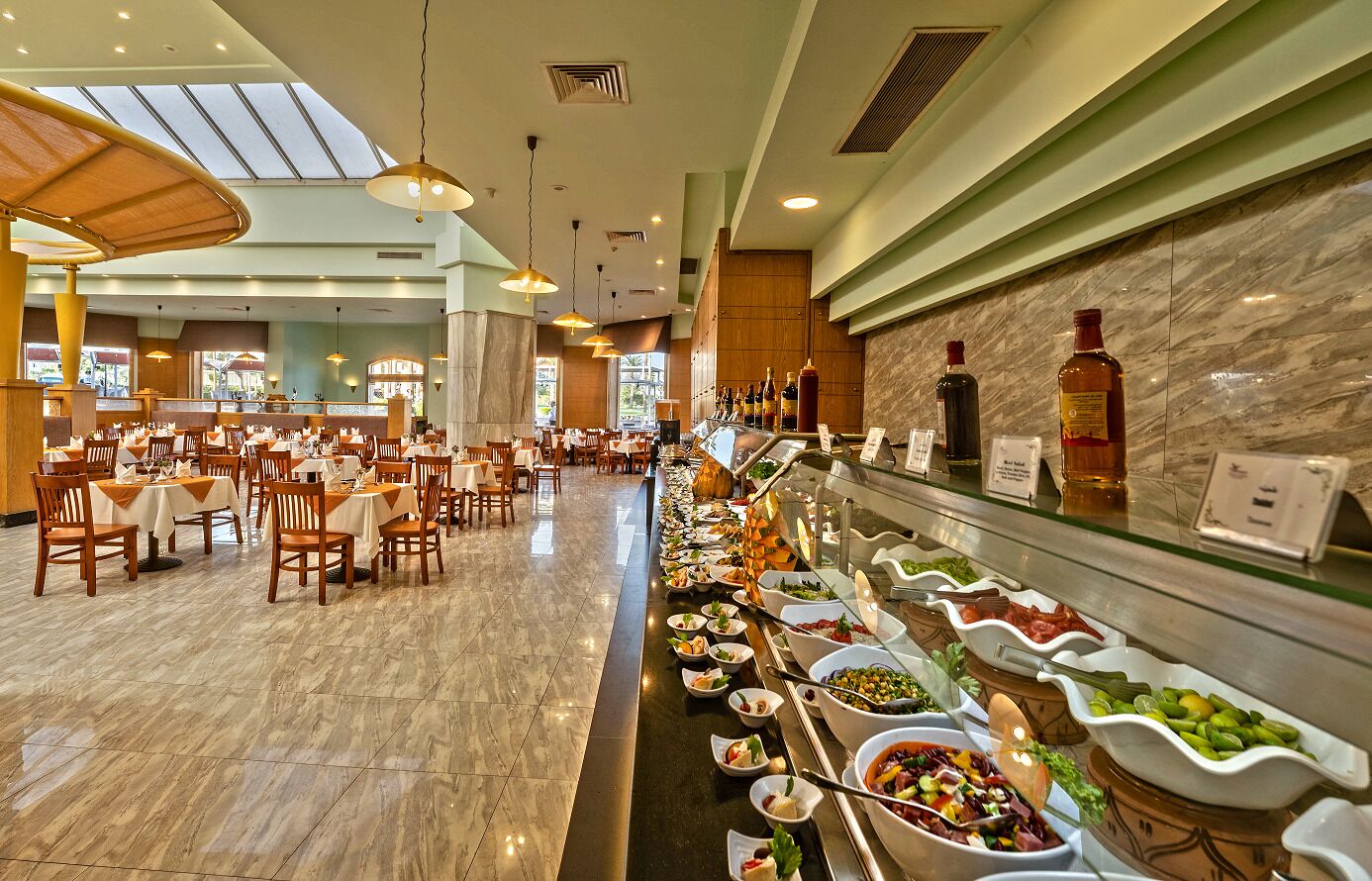 A buffet area with multiple food stations and a seating area with tables and chairs.