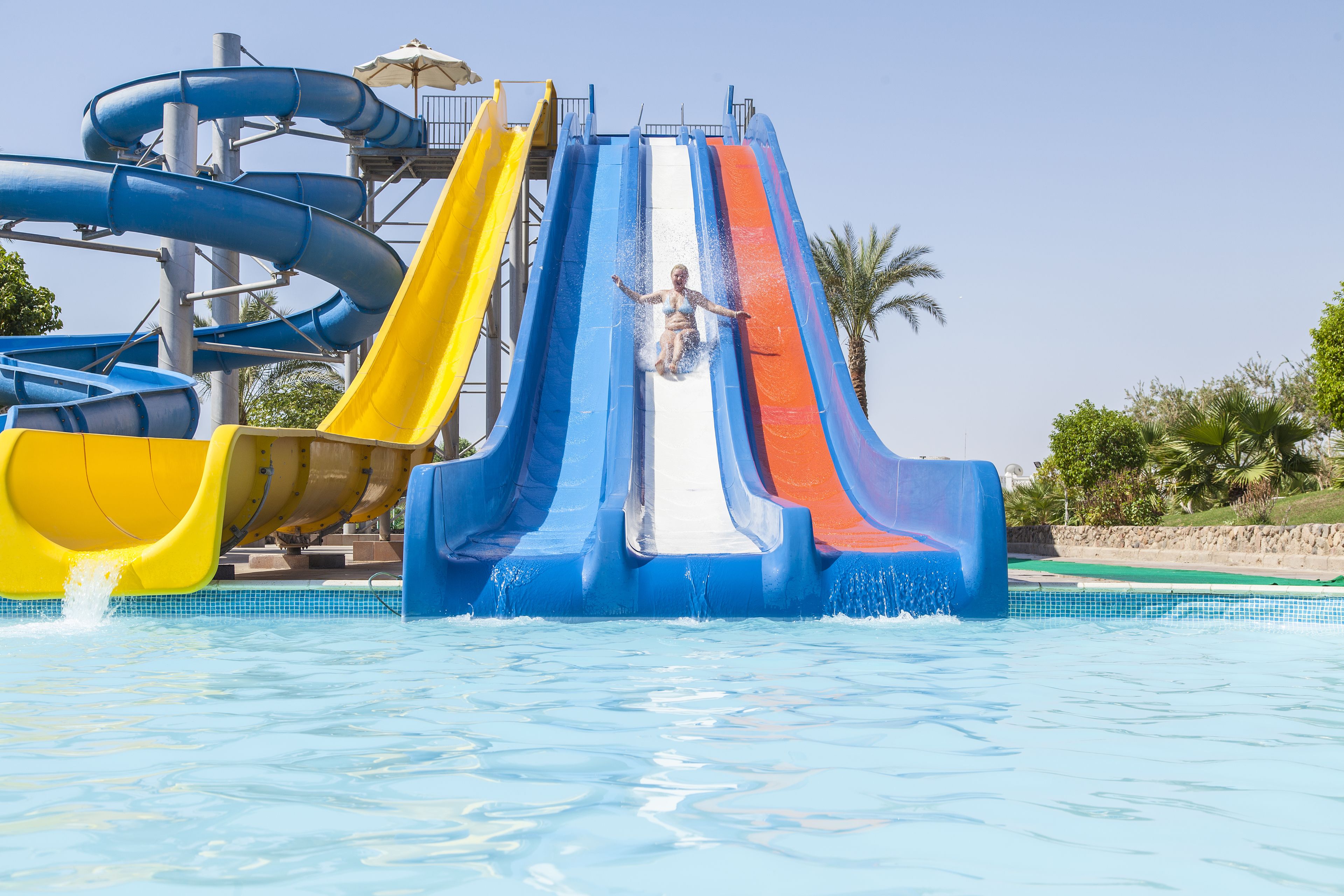 Un parc aquàtic amb diverses tobogans, als colors blau, groc i vermell.