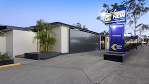 Un edificio moderno con un gran letrero que dice Tooheys New Shortland Hotel & Motel.