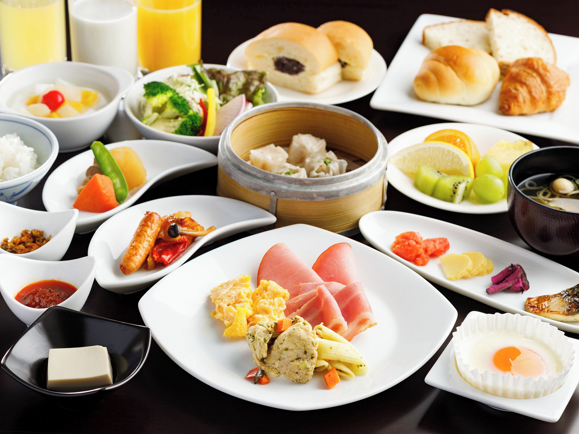 A variety of dishes including sushi, sashimi, and a bowl of soup.