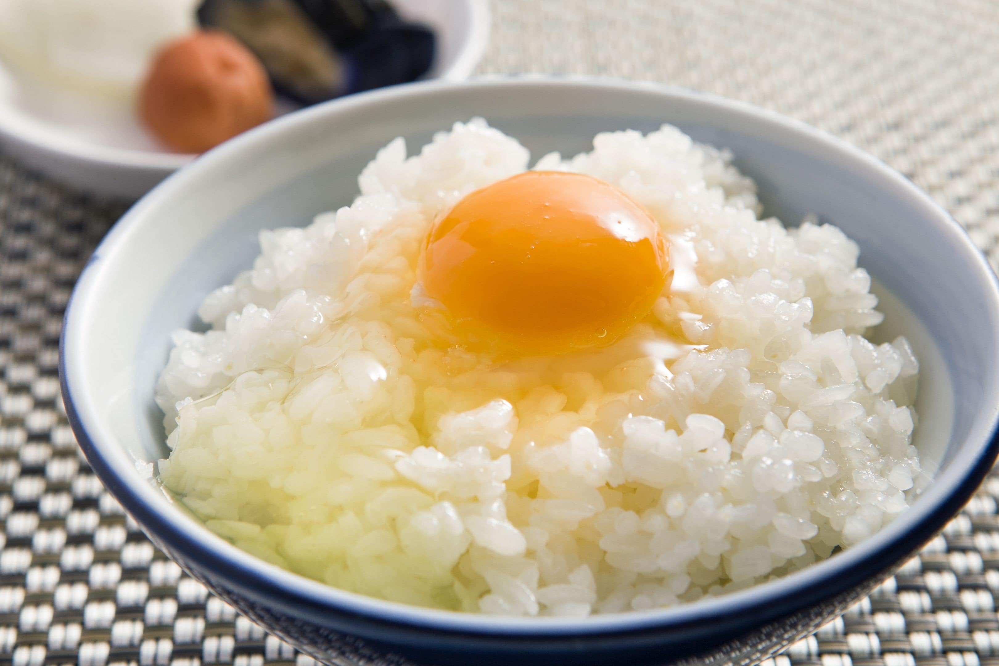 A bowl of white rice with a raw egg yolk on top.
