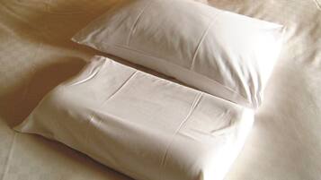 A bed with two pillows and a checkered blanket.