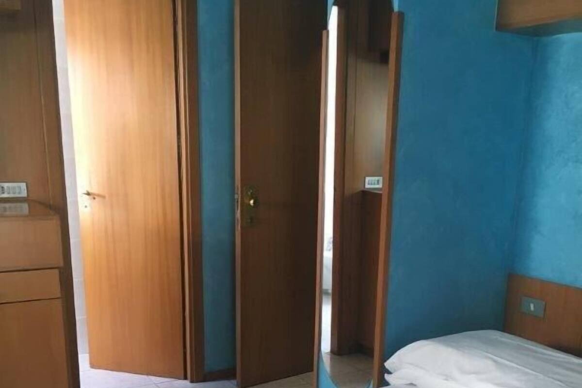 A bedroom with a bed, a wardrobe, and a door.