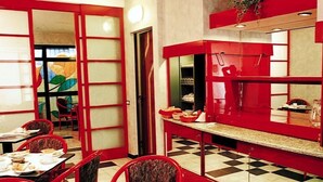 A restaurant with red decor, checkered flooring, and a large window with a colorful view. - Hotel Residence D'Azeglio (Turin)