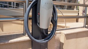 A Tesla charging station with a clear view of the adjacent building and outdoor seating area. - Hotel Epavlis Eleftheriadi (Katerini)
