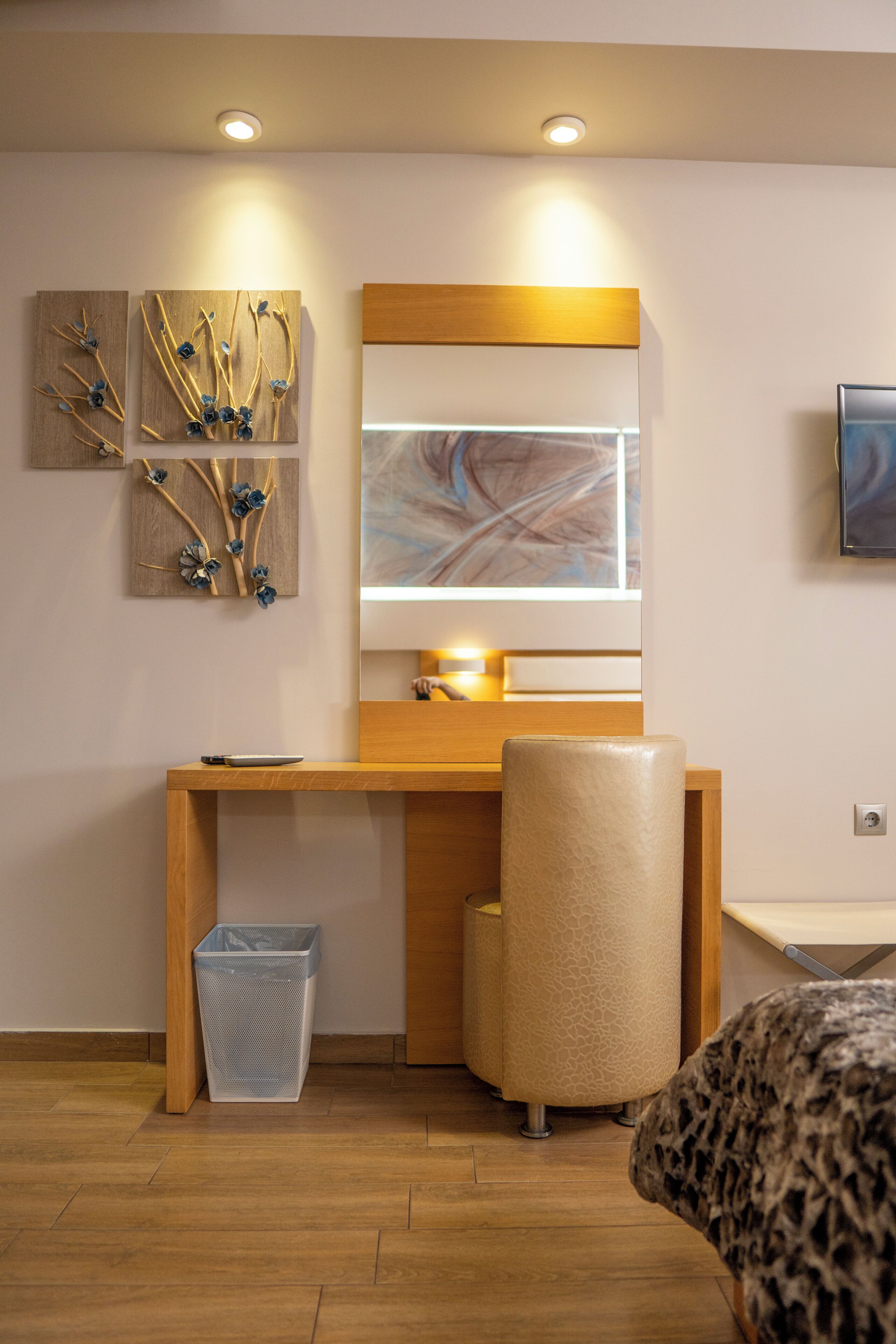 Una habitación moderna con un escritorio de madera, un espejo grande y una cama con estampado de leopardo.