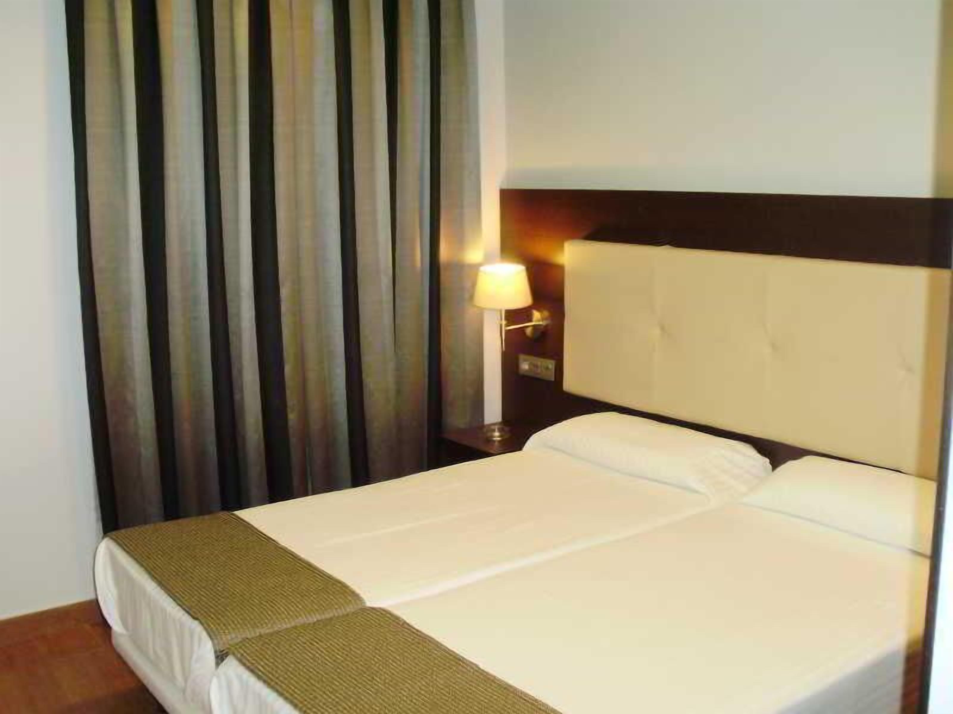 1 dormitorio, ropa de cama de alta calidad, escritorio y cortinas opacas