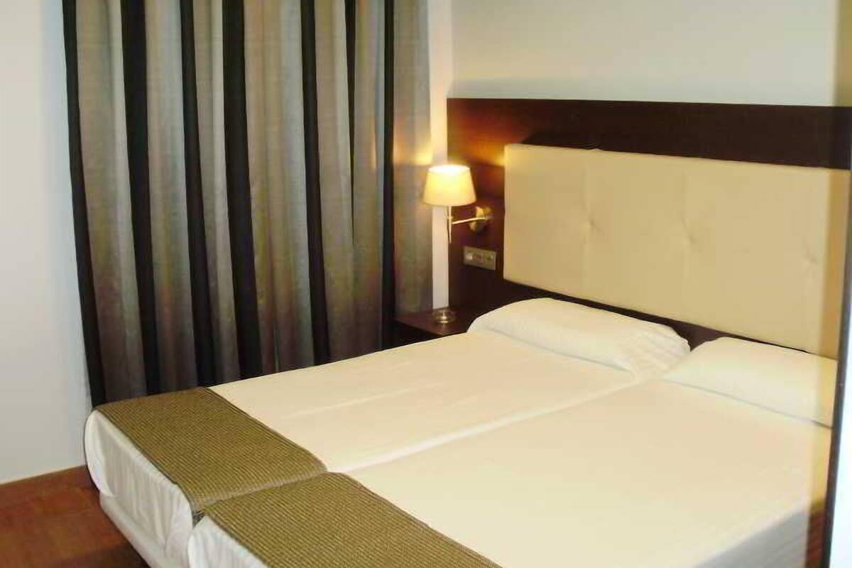 1 dormitorio, ropa de cama de alta calidad, escritorio y cortinas opacas