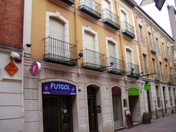 Ein Gebäude mit einer Schaufensterbeschriftung „FUTGOI ESPECIALISTAS DEL FUTBOL“ und einem grünen Schild für „DOCE + UNO“.
