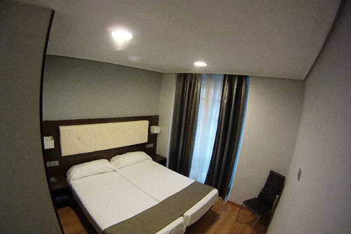 1 dormitorio, ropa de cama de alta calidad, escritorio y cortinas opacas