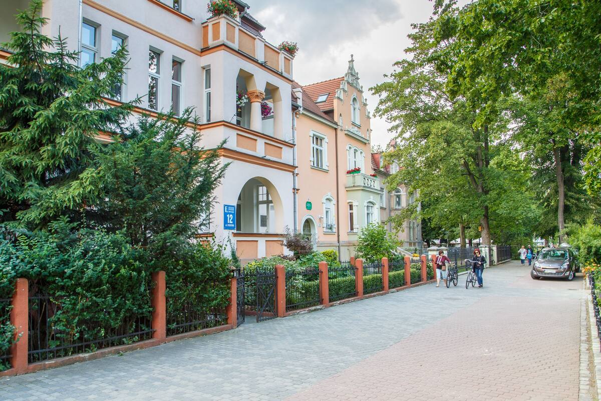 A cobblestone street lined with historic buildings, a bicycle, and pedestrians.