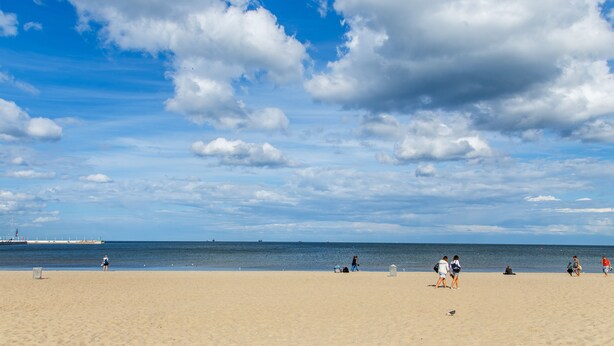 A wide sandy beach with a clear sky and a few clouds. - Apartments Happy Hours (Sopot)