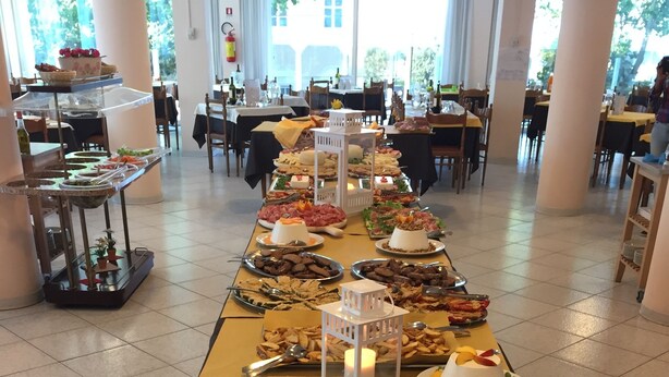 A buffet table with various dishes and a white lantern in the center. - Hotel Beverly (Rimini)