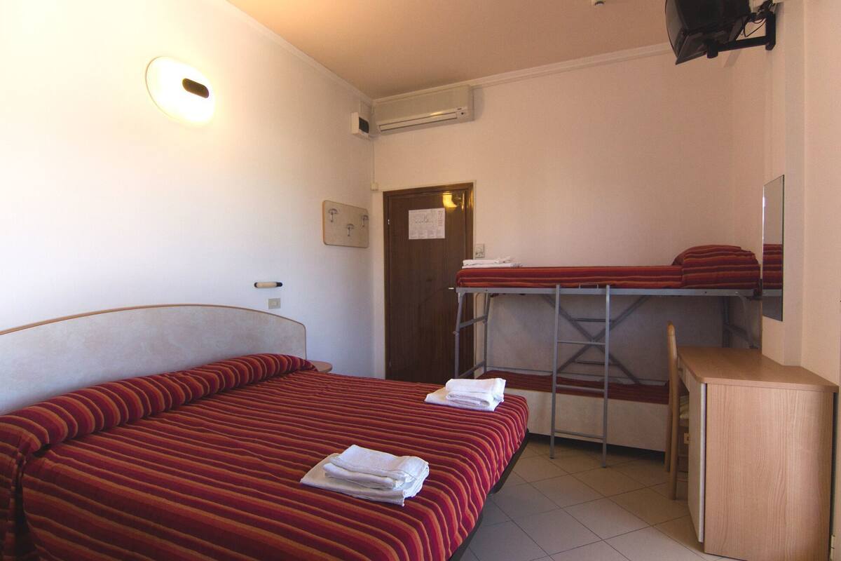 A room with a single bed, a desk, and a bunk bed.