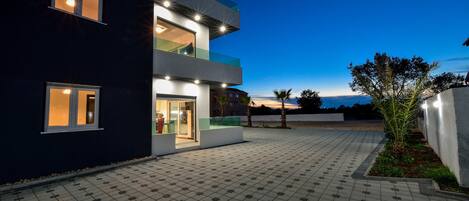 A modern building with multiple floors, large windows, and a paved courtyard.