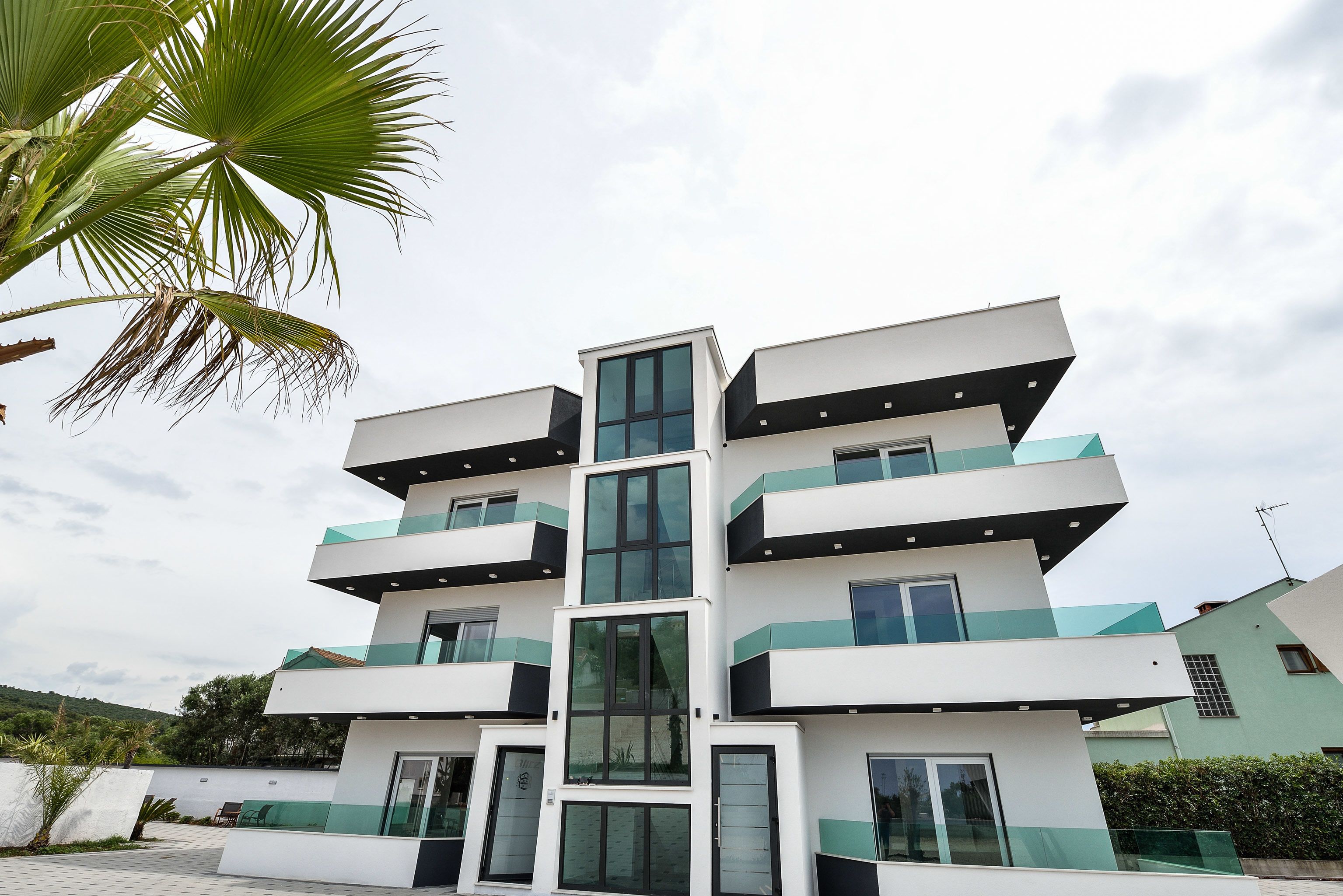 Un edificio de varios pisos con balcones y ventanas amplias.