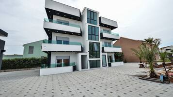 Stylish residential building with spacious balconies and large windows, offering a pleasant outdoor area with a garden.