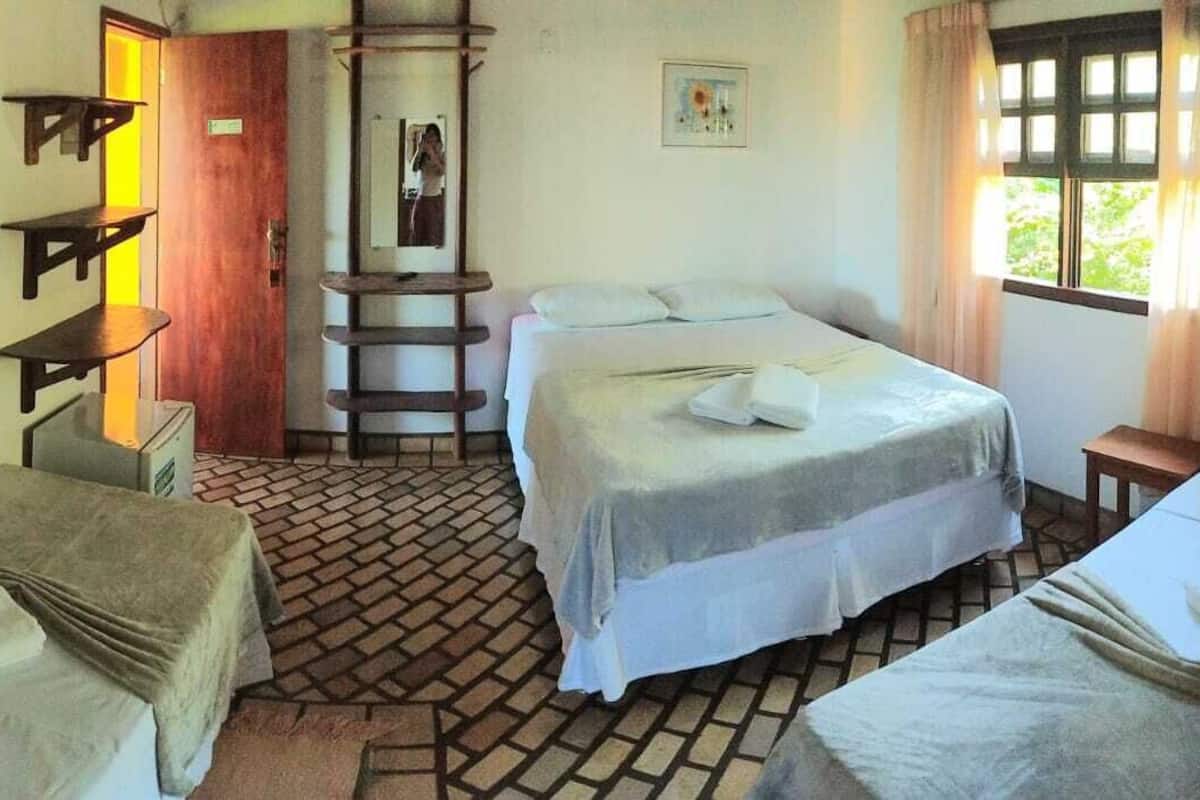 A room with a bed, a small table, a shelf, and a ladder.