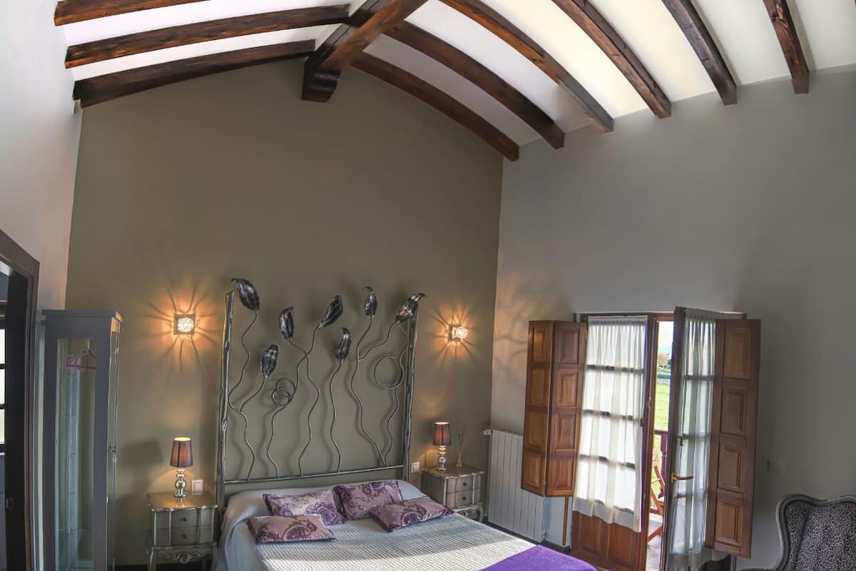 Un dormitorio con cama, lámparas de noche, un armario y una silla.